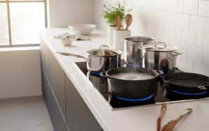 Plaque induction 4 feux en cuisine moderne avec ustensiles compatibles